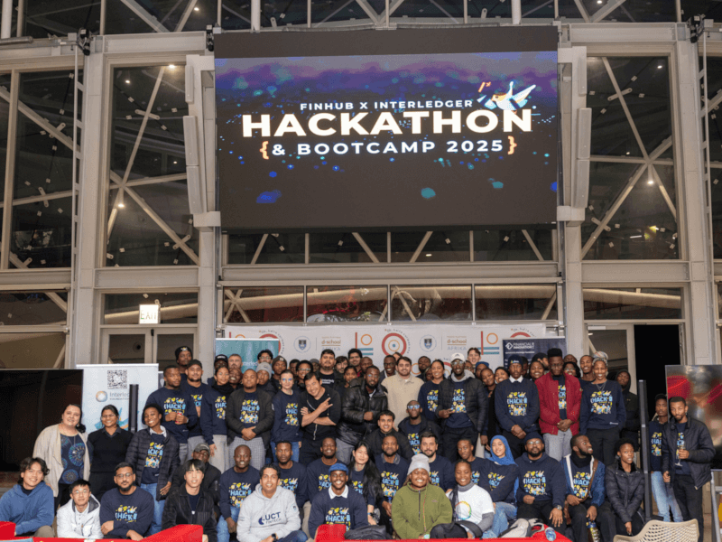 Group photo of all hackathon participants standing on stage at the UCT Financial Innovation Hub.